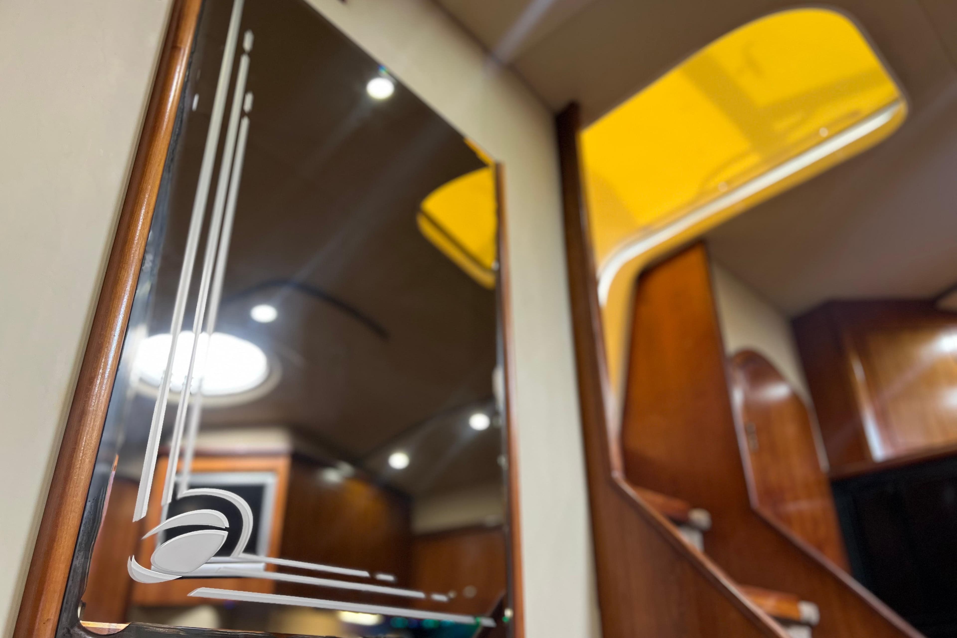 Interior of 2005 Cruisers Yachts 440 Express, featuring elegant wood finishes and modern lighting.