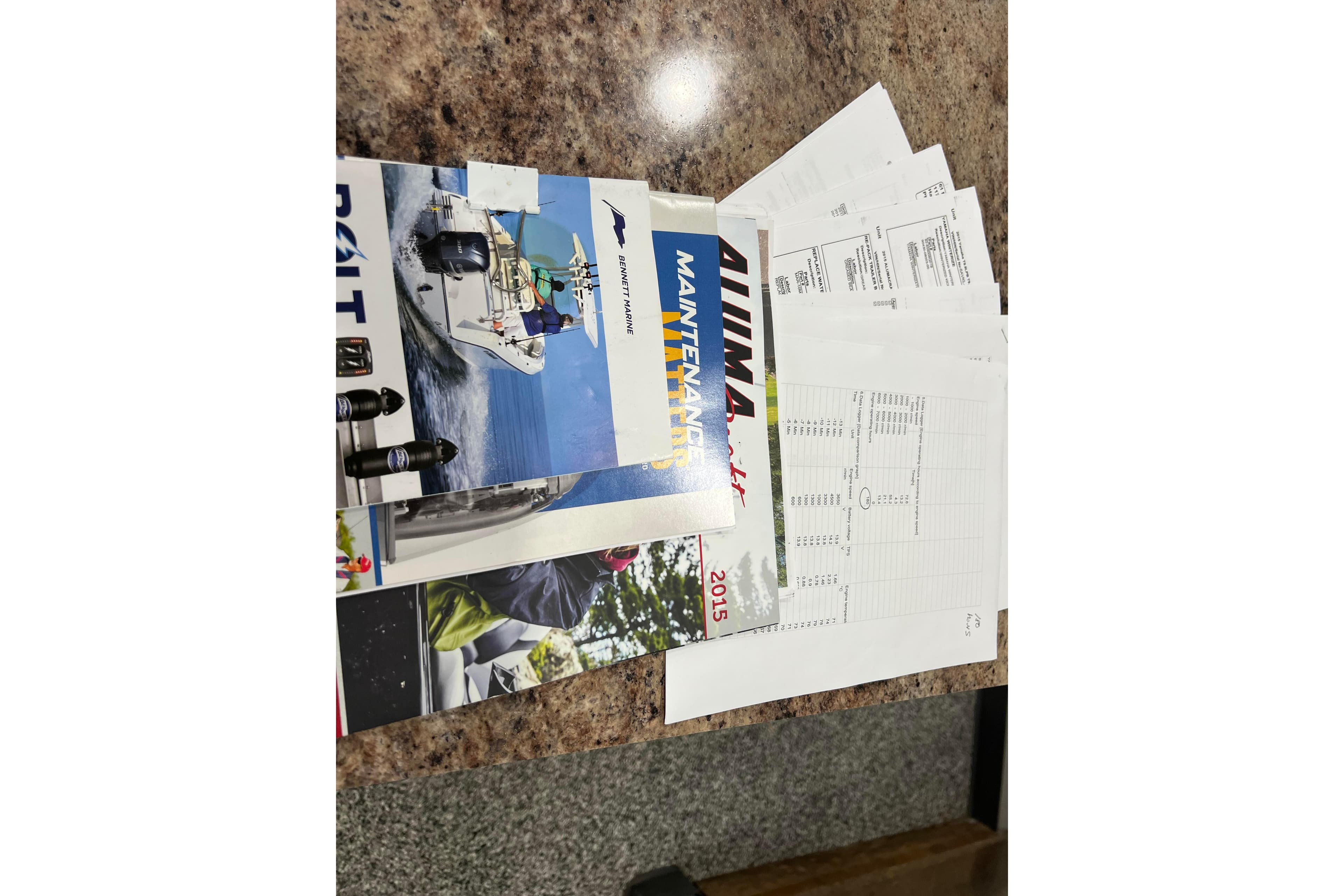 Assorted Alumacraft Trophy 205 Sport 2015 manuals and documents on a table.