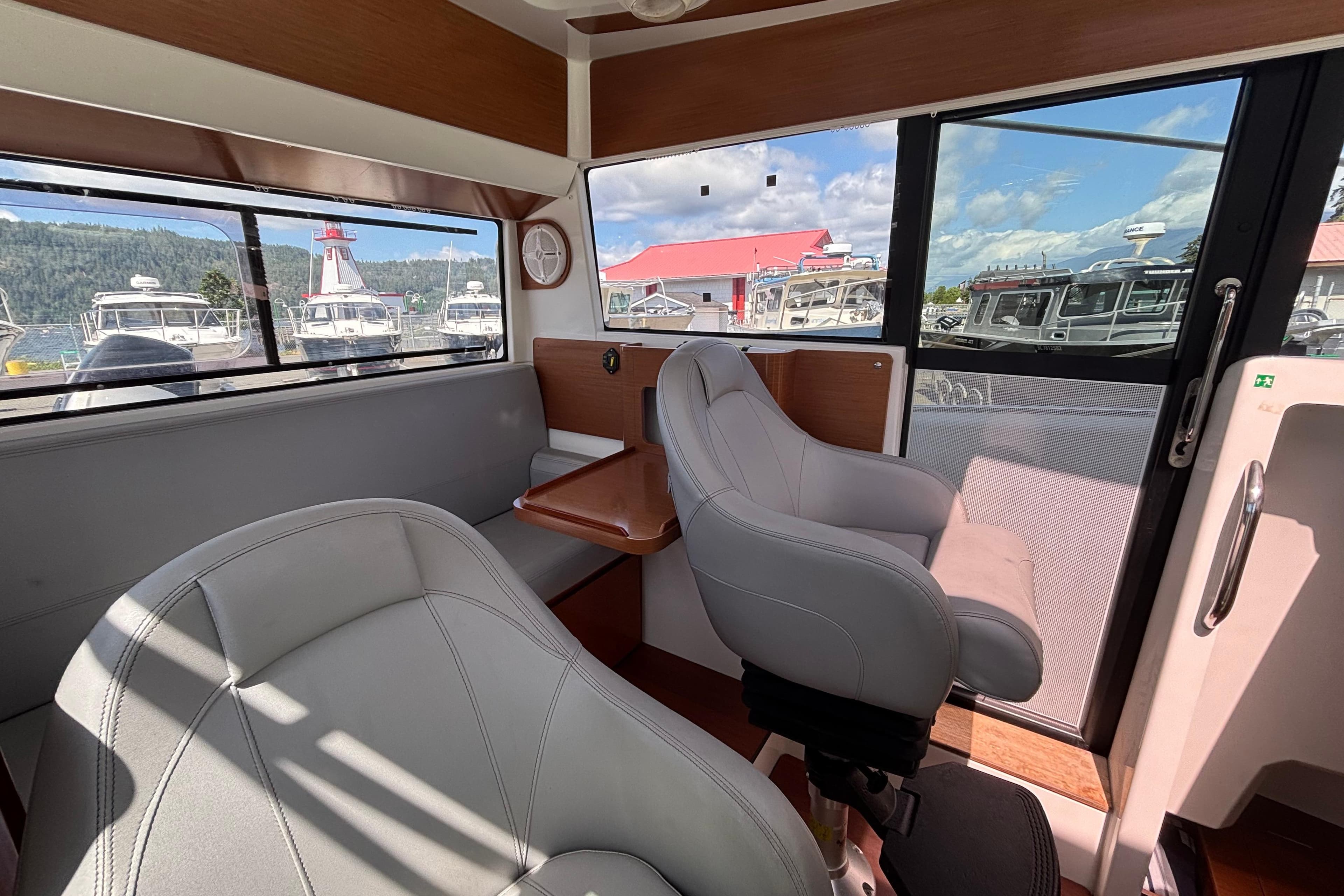 Interior of 2013 Beneteau Barracuda 9 Fly boat with seating and window view.