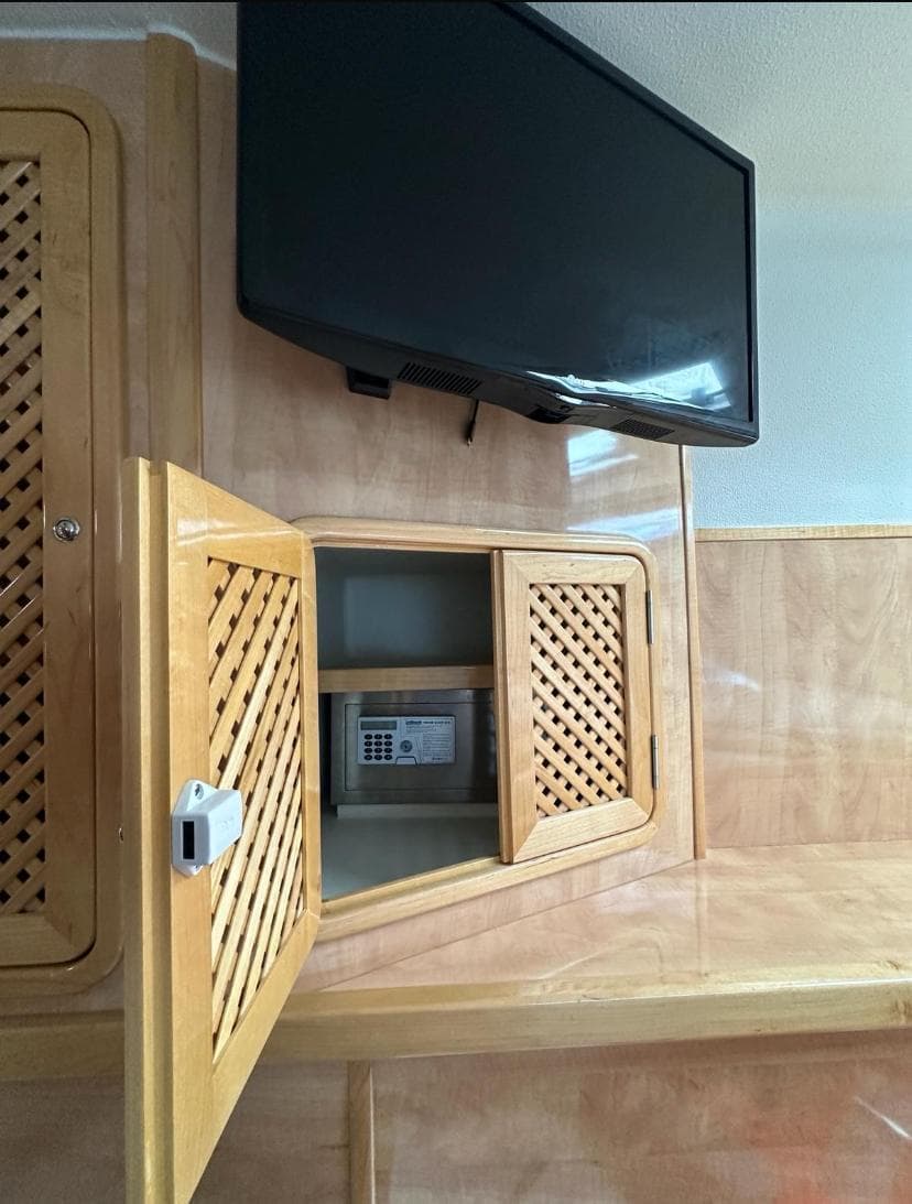 Interior of 2018 Knysna 500 SE with TV, wooden cabinets, and safe.