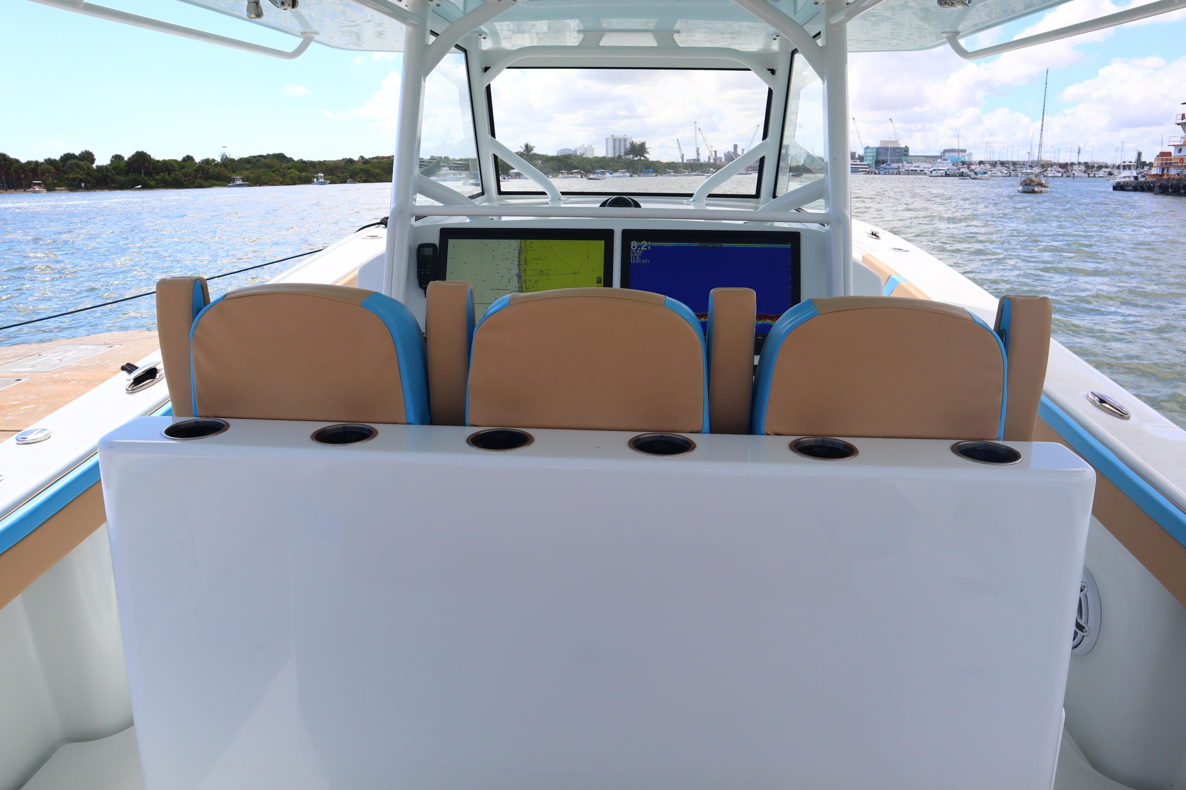 2022 Yellowfin 42 Offshore boat interior with navigation screens and seating, on a calm waterway.
