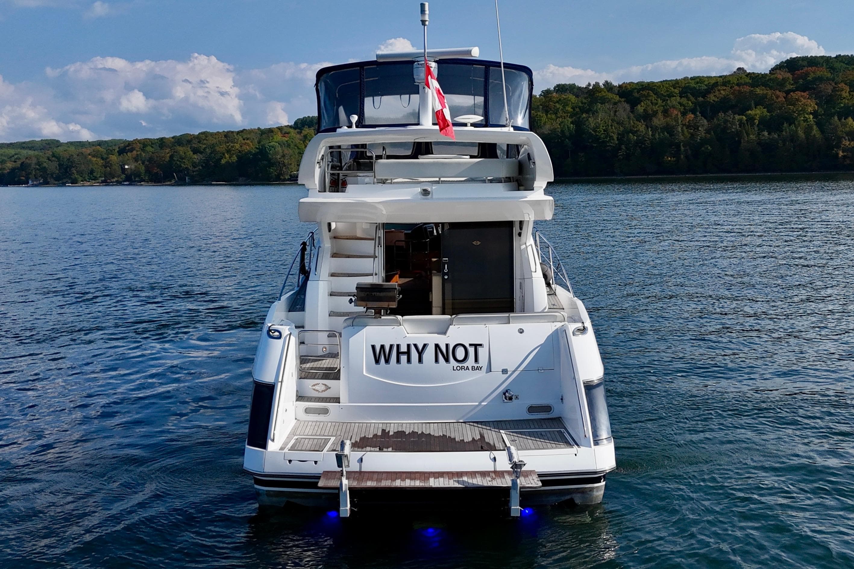 2005 Sunseeker Manhattan 50 yacht on serene lake with lush forest backdrop.