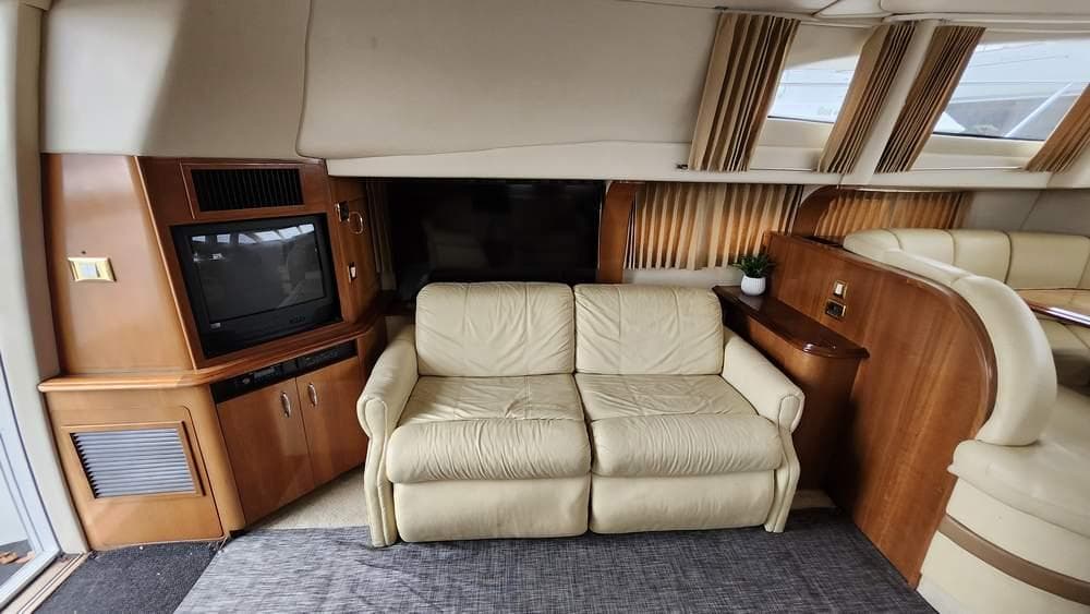 Interior of 2005 Carver 420 Mariner yacht with beige sofa and built-in TV.